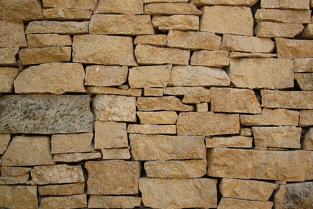 Mur de pierres dorées assisées en lits horizontaux, joints fins