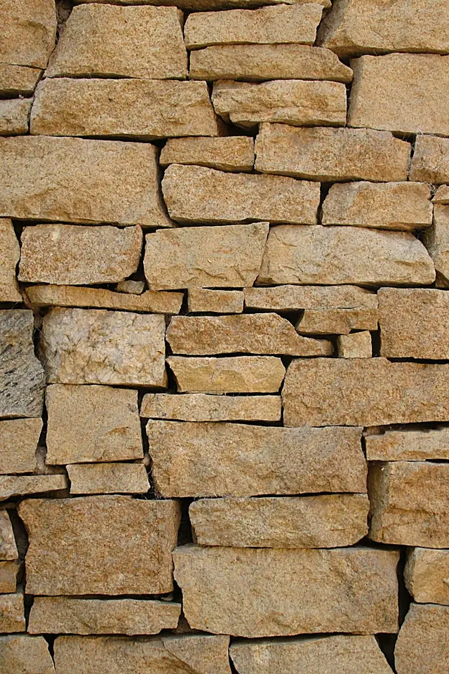 Mur de pierres dorées assisées en lits horizontaux, joints fins